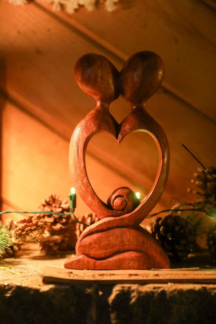 Kissing carved wooden sculpture in heart