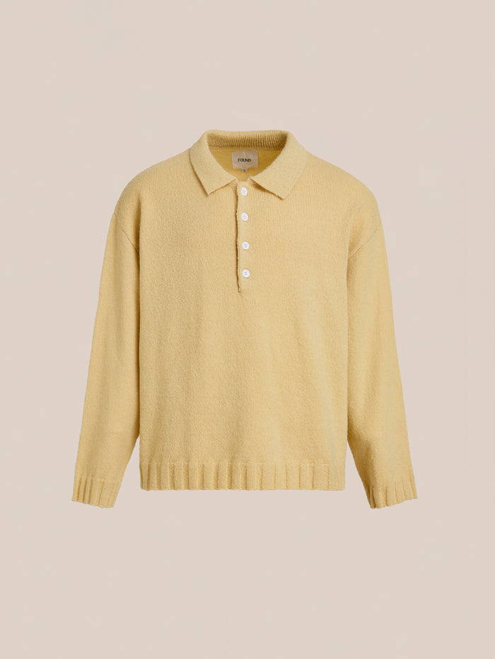 The FOUND Knit LS Polo Sweater features a light yellow hue, collar, five white buttons, and soft brushed knit fabric, shown against a plain beige background.