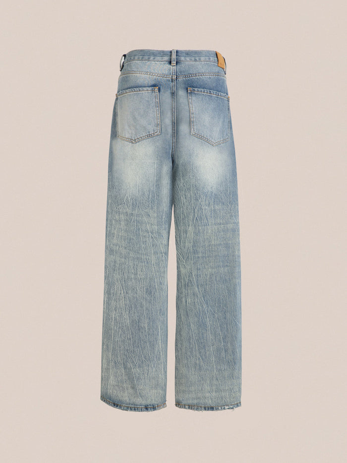 Back view of Found Lacy Baggy Jeans in light blue denim with a worn texture, showcasing two back pockets, distressed hems, and a tan leather patch on the waistband.