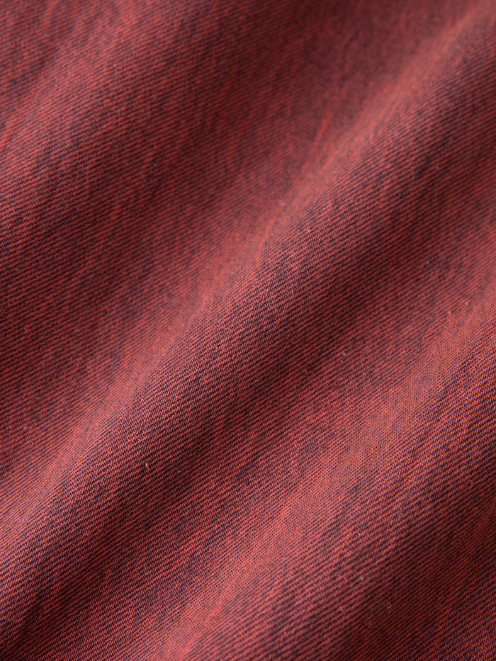 A detailed close-up of the woven pattern in vintage red, reminiscent of FOUND's Lacy Baggy Jeans with a textured diagonal ripple effect.