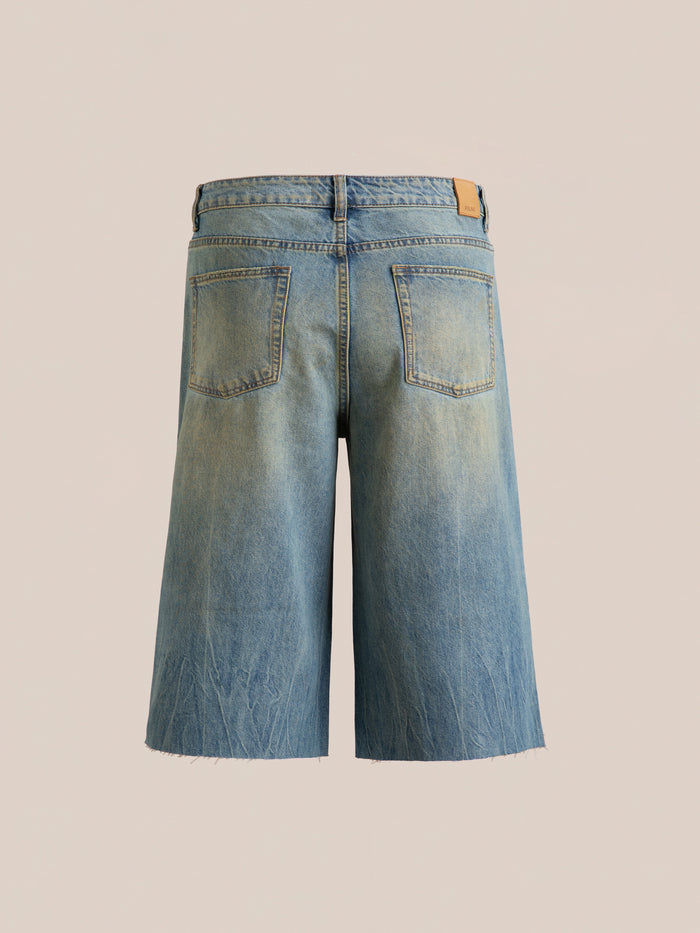Back view of FOUND's Lacy Jean Jorts, featuring mid-length faded denim with frayed hems and two back pockets, set against a neutral background.