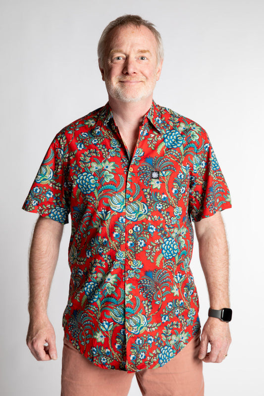 Chris, 5'7", wearing the LaLa Printed Cotton Button Up in red Crimson Garden, size M