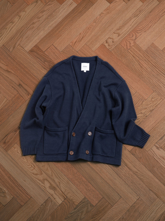 A Found Larsi Double Breasted Knit Cardigan sitting on a wooden floor.