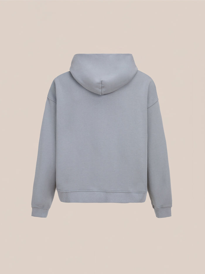 Back view of the FOUND Logo Patch Hoodie in washed gray, featuring a unisex relaxed fit, shown against a neutral background.