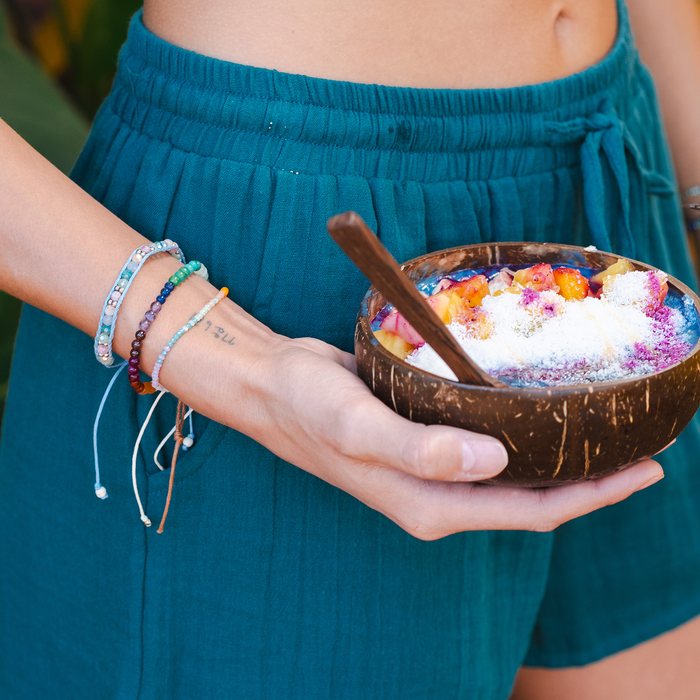 Lost Paradise Healing Bracelet, stacked on wrist holding acai bowl