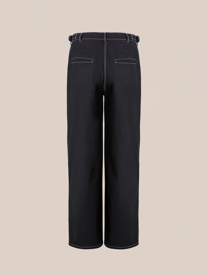 The Lucca Black Contrast Pocket Pants by FOUND are high-waisted black utility trousers featuring a relaxed straight-leg fit, white stitching, belt loops, and two back contrast pockets, showcased against a plain beige background.
