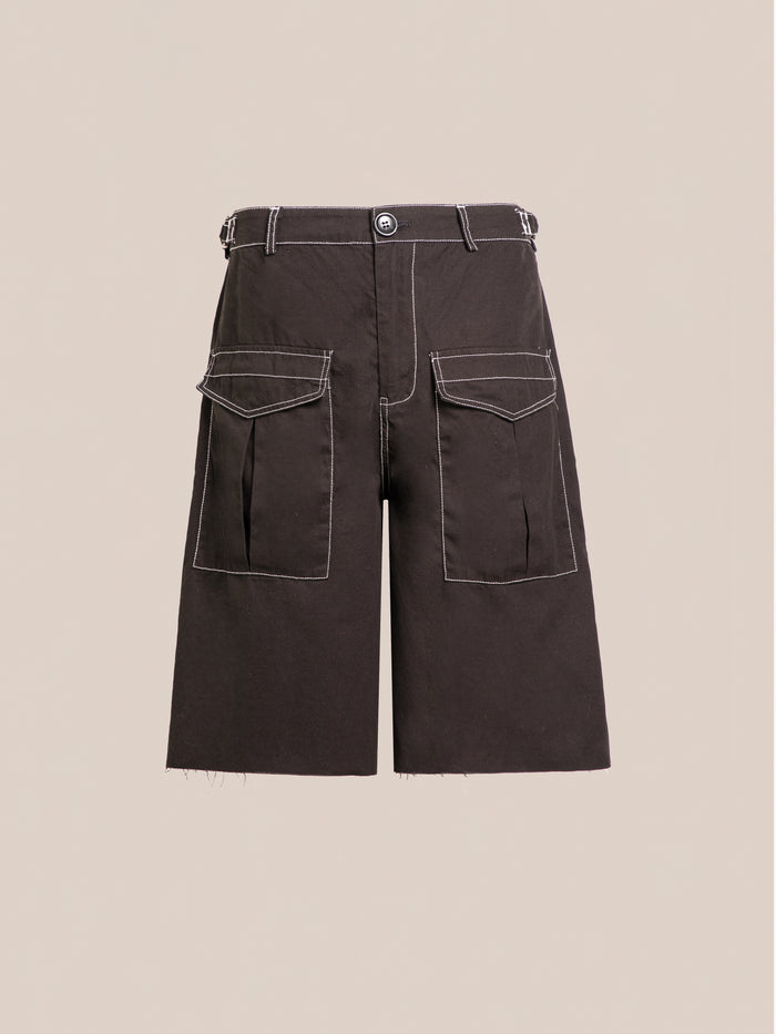 The Lucca Black Contrast Pocket Trouser Shorts by FOUND feature white stitching, two large front pockets, a relaxed fit, button closure, and belt loops. They are displayed against a plain beige background.