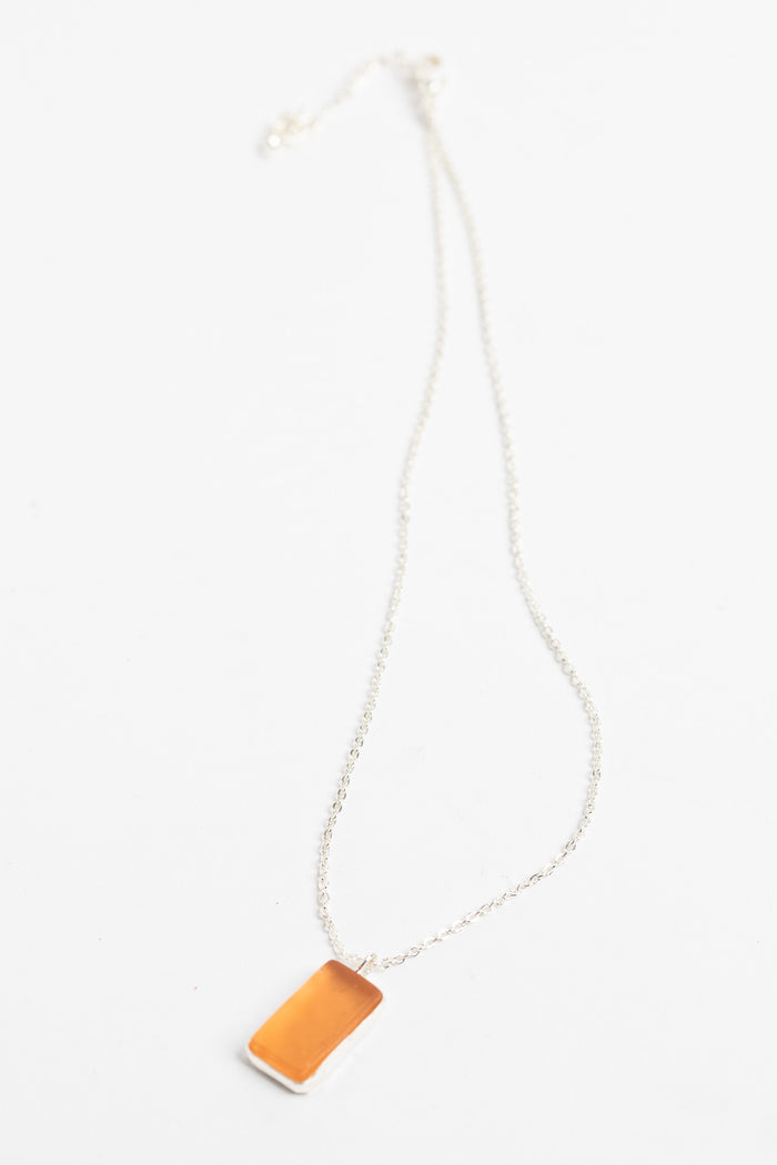 minimalist boho necklace pendant in pink on white background