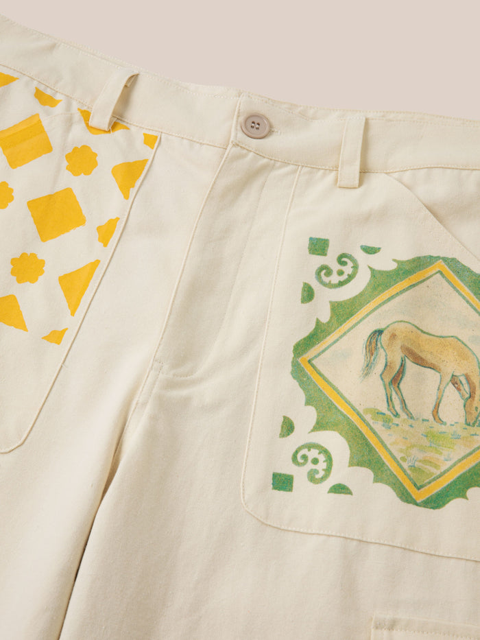 FOUND's unisex Mosaic Pants blend beige fabric with yellow geometric and Indo-Aryan patterns, highlighted by a unique horse illustration on the pockets.