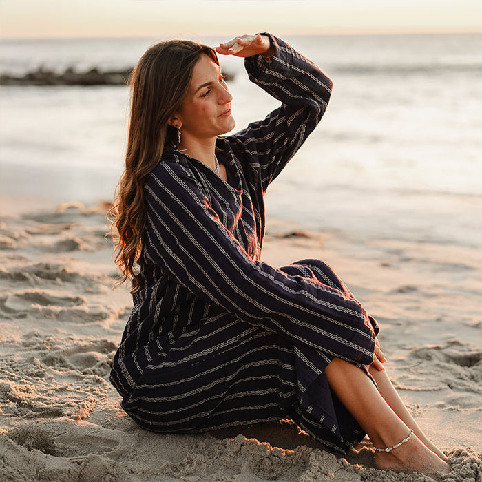 Navy Sailor Stripe Baja Pullover, seated on the beach