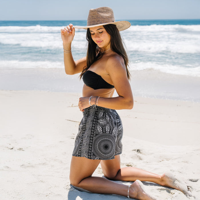 Odesa Shorts, kneeling on the beach