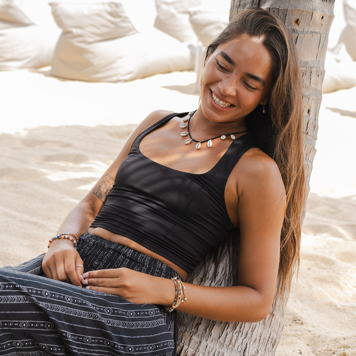 Onyx Vinyasa Tank, worn seated on the beach