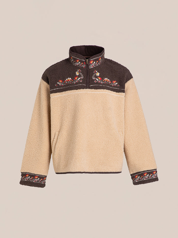 The Pahari Floral Embroidered Sherpa Pullover by FOUND features a beige design with dark brown accents and floral embroidery on the collar, chest, and sleeves.