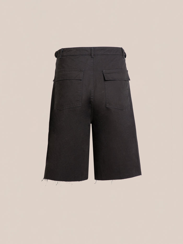 Found Parachute Cargo Twill Shorts in black, shown from the back with two pockets, belt loops, and raw hems against a beige background—exuding a laid-back utility style.