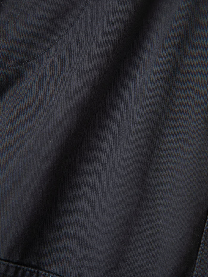 Close-up view of black fabric with visible stitching and a curved seam near the upper left corner, highlighting the durable construction typical of Found's Parachute Cargo Twill Shorts.