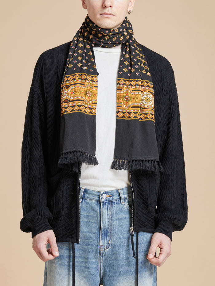 A man wearing a Found Pastures Print Scarf with hand-tied tassels.