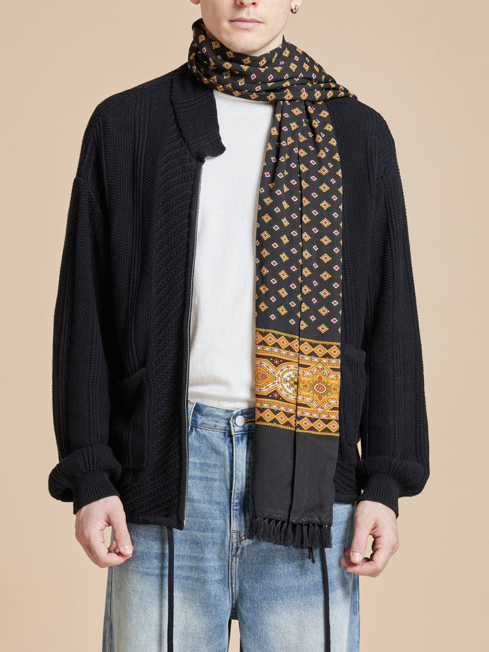 A man wearing a Found Pastures Print Scarf with hand-tied tassels.