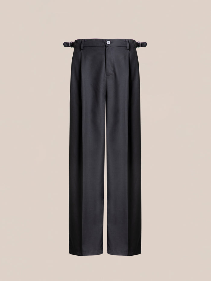 Image of a pair of Pleated Trousers from Found, displayed against a beige background, featuring adjustable waist tabs and a front button closure.