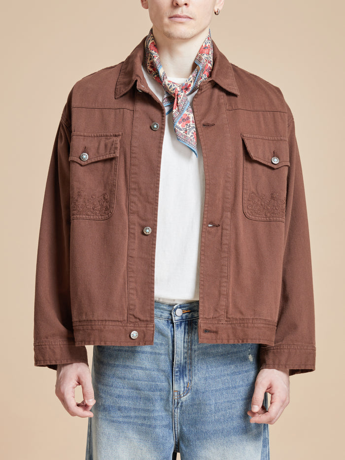 The model is wearing a brown jacket and jeans with Found's Poinciana Bandana prints.