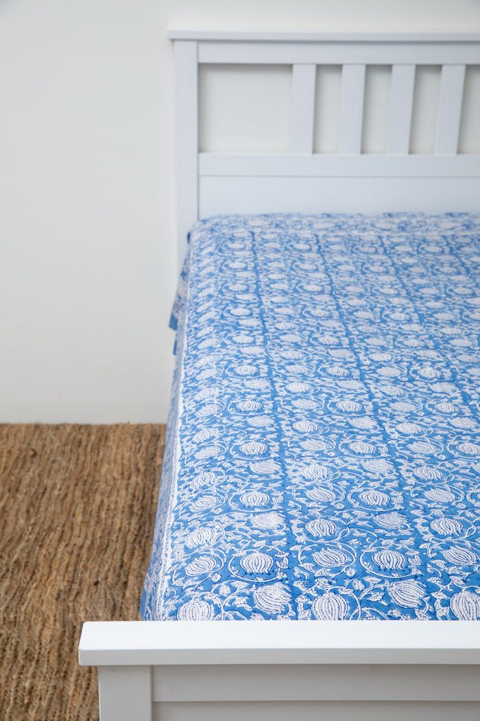 Bohemian block print tapestry in Blue Poppies, displayed as a bedspread