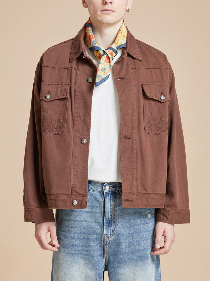 A man wearing Rainforest Bandana artwork on a brown jacket.