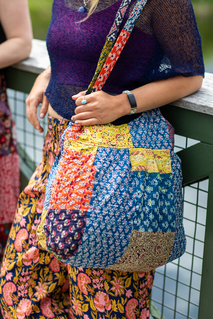 Woman holding patchwork shoulder bag.