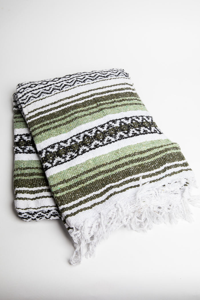 Striped recycled blanket with green, white, and black pattern on a white background