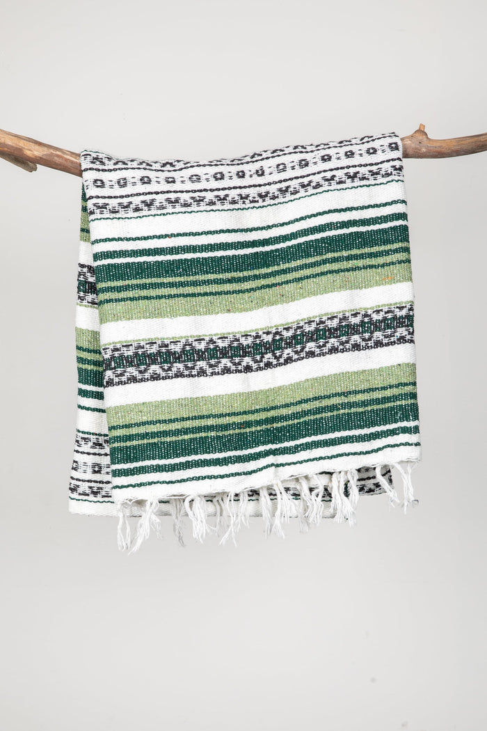 Striped recycled blanket with green, white, and black pattern on a white background