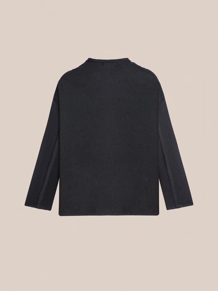The FOUND Reversed LS Tee in plain black, featuring a relaxed fit, is displayed flat with the back side facing up against a neutral background.