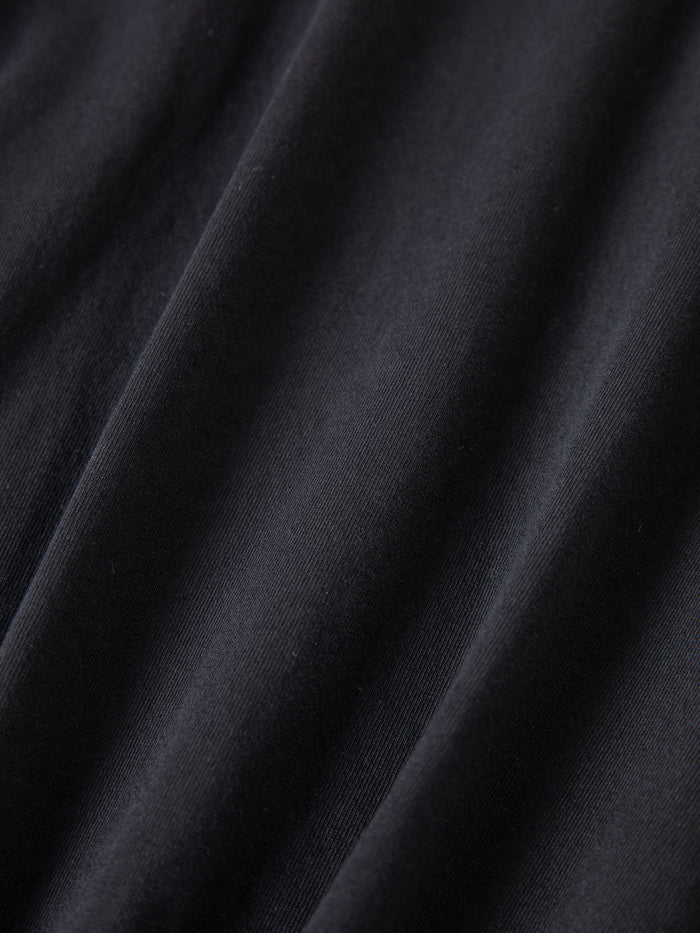 Close-up of smooth black fabric from the FOUND Reversed LS Tee, showing soft folds and subtle diagonal lines for a relaxed, unisex fit.