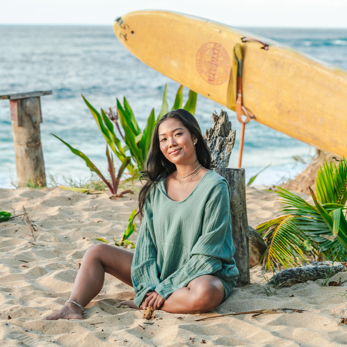 Sage Baja Pullover, worn seated on the beach