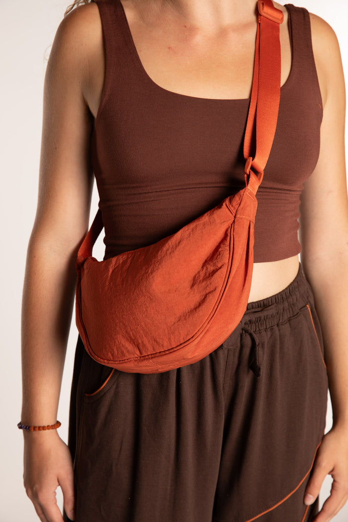Emily is wearing the Samui Shoulder Bag in Rust