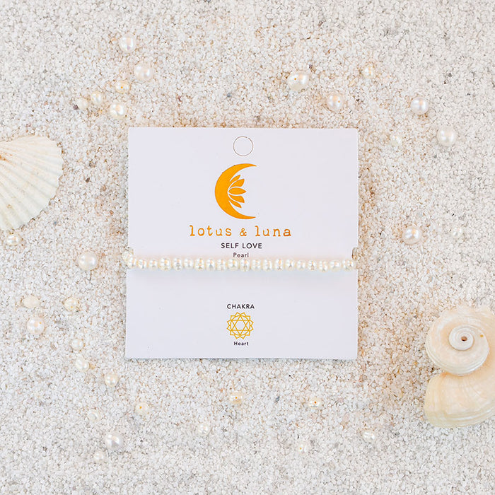 Self Love 4mm Healing Bracelet, on card on sand