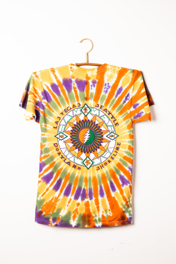 Colorful Grateful Dead tie-dye t-shirt with a geometric design on a hanger against a white background