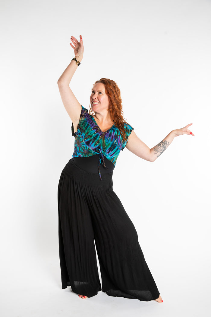 Maggie is wearing the Blue Ocean Tie Dye Cinch Crop Top and Black Penny Lane Pants