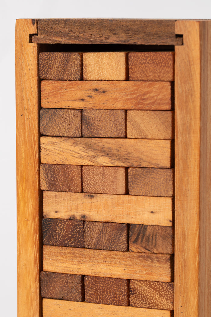 Close view of smooth wooden stacking blocks showing natural grain and warm tone — handcrafted Timber Tumble game.