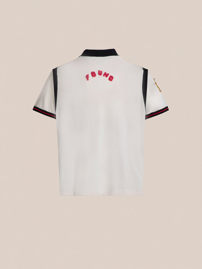The Union Soccer Jersey by FOUND is a white short-sleeve shirt featuring black collar and sleeve details for a modern touch. "FOUND" is embroidered in bold red letters across the upper back, evoking a vintage football style.