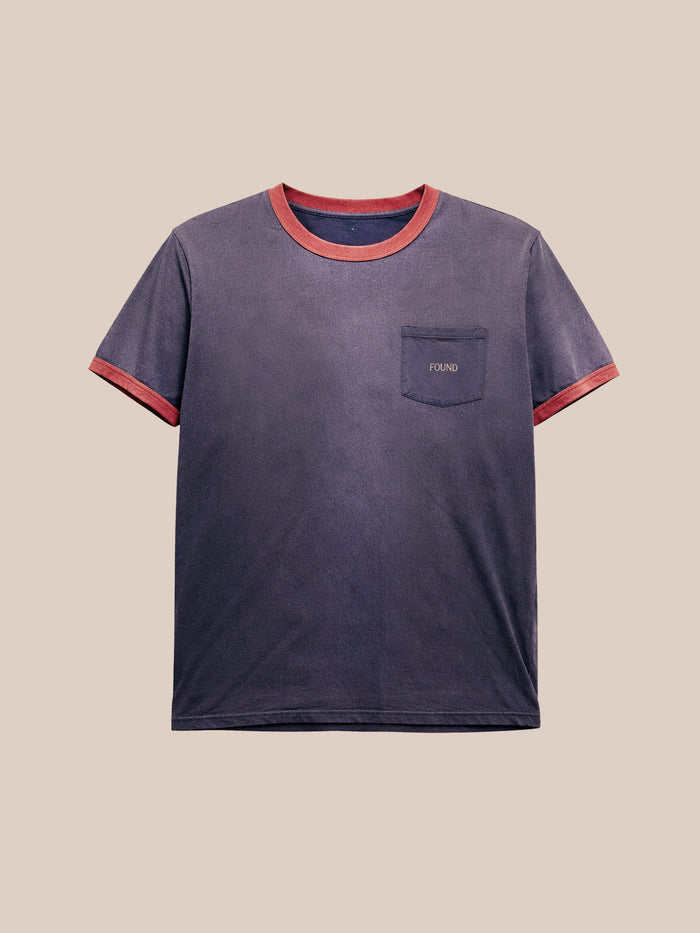 The FOUND Washed Ringer Logo Tee is a navy short-sleeve vintage athletic shirt with a relaxed fit, red collar and cuffs, and a chest pocket featuring an embroidered "FOUND" logo.