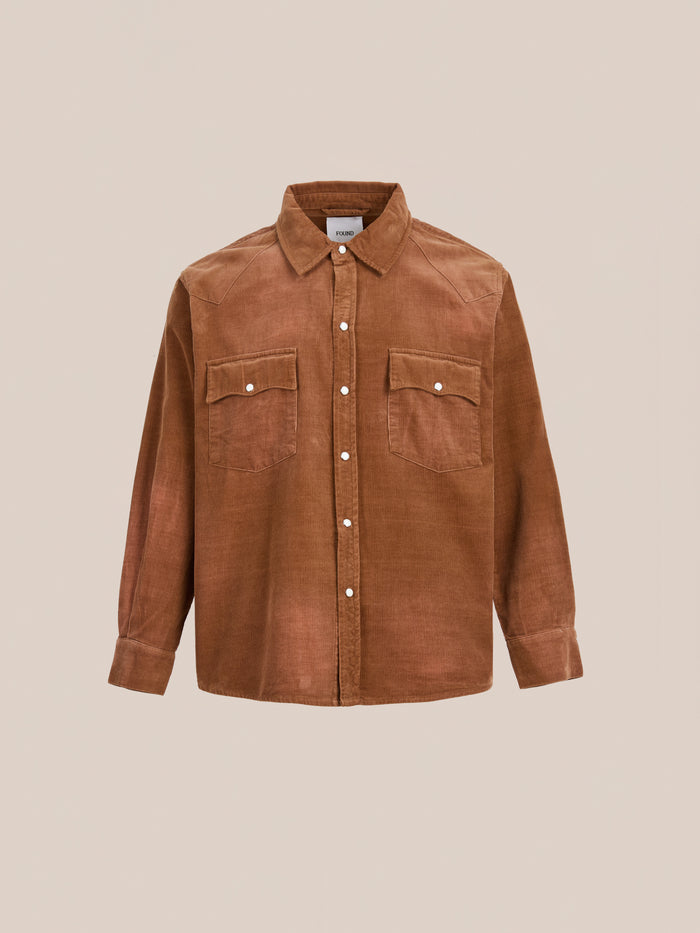 The FOUND Western Corduroy Shirt features brown corduroy, long sleeves, two chest pockets, and a unisex relaxed fit, shown against a plain beige background.