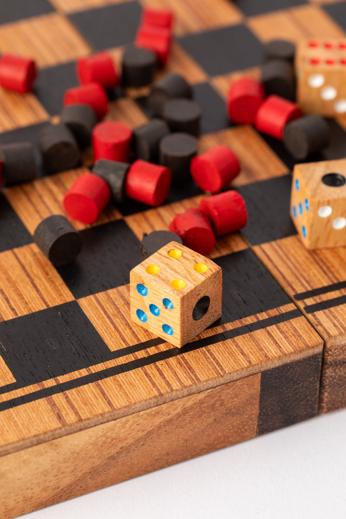 Wooden dice and red and black game pieces on handcrafted checkers board — sustainable wooden gift under $50.