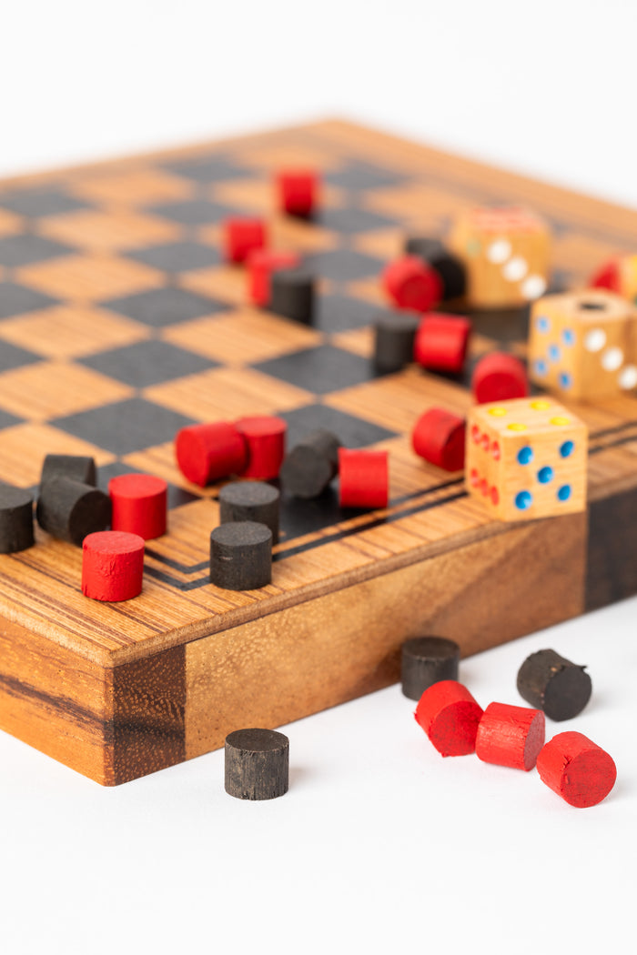 Wooden checkers pieces and dice on handcrafted game board — bohemian home decor accent.