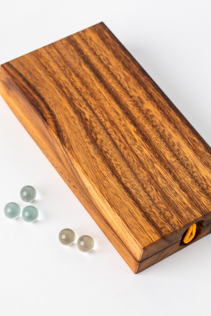 Folded wooden mancala board with marbles beside it — handmade gift under $50 for home or kids room.