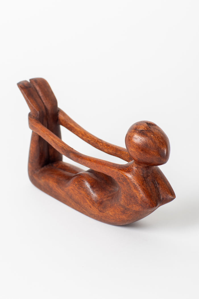 Wooden yoga sculpture in bow pose